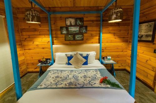 a bedroom with a bed in a room with wooden walls at Polo Cherrapunjee Resort in Cherrapunji