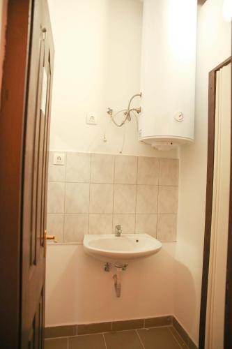 a bathroom with a sink and a white cabinet at Déjá Vu Szállás & Rendezvény Zirc in Zirc