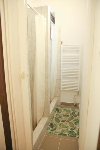 a bathroom with a shower and a rug at Déjá Vu Szállás & Rendezvény Zirc in Zirc
