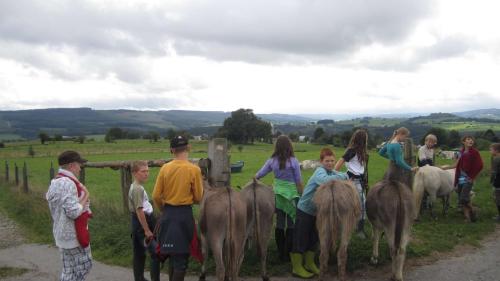 a group of people standing next to a group of animals at Le Fagotin - Youth hostel in Stoumont