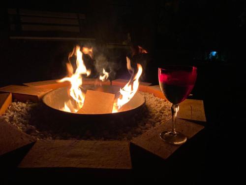 a glass of wine sitting next to a fire pit at Pousada Santa Genoveva campeche in Florianópolis