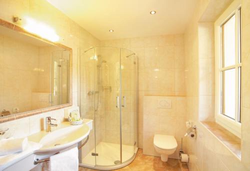 a bathroom with a shower and a sink and a toilet at Alpenherz Hotel Garni in Gerlos