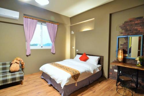 a bedroom with a bed and a fireplace and a window at 艾兒民宿 l 台東包棟 l 按訂房人數開放房間8-21人 in Taitung City