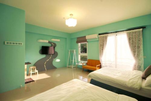 a bedroom with green walls and two beds and a window at 艾兒民宿 l 台東包棟 l 按訂房人數開放房間8-21人 in Taitung City