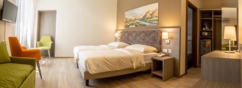 a hotel room with a large bed and a desk at Hotel Unione in Bellinzona