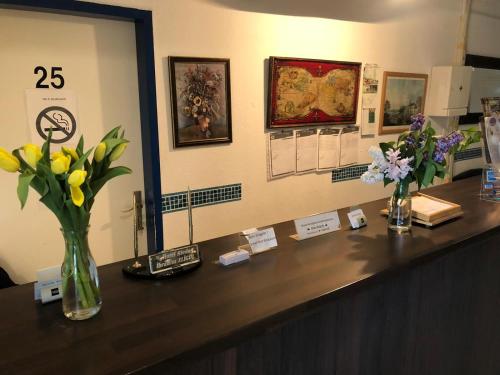 a reception desk with flowers in vases on it at Hotel Riede in Bremen