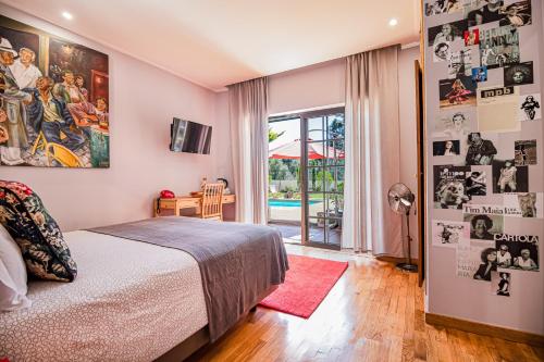 ein Schlafzimmer mit einem Bett und ein Zimmer mit einem Pool in der Unterkunft Buganvilias Do Meco Guest house in Sesimbra