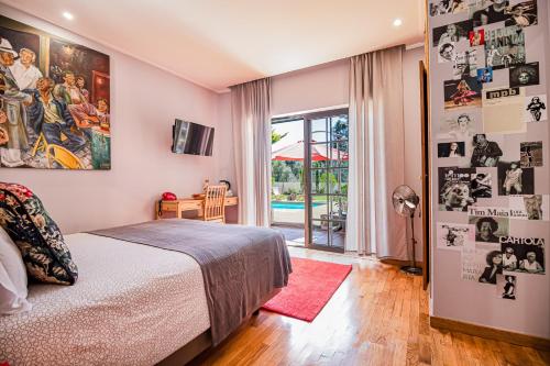 a bedroom with a bed and a room with a pool at Buganvilias Do Meco Guest house in Sesimbra