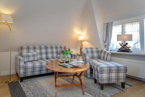 a living room with a couch and two chairs and a table at Boutiquehotel Seiler Hof Keitum in Keitum