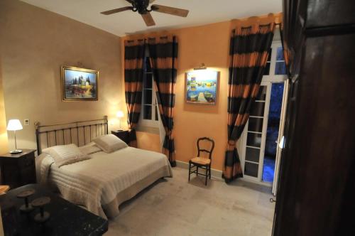 a bedroom with a bed and a chair and a window at Domaine du Grand Malherbes in Aimargues