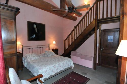 a bedroom with a bed and a stair case at Domaine du Grand Malherbes in Aimargues