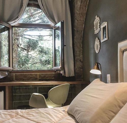 a bedroom with a bed and a window at Pousada Castello Benvenutti in Bento Gonçalves