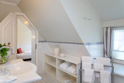a white bathroom with a sink and a mirror at Boutiquehotel Seiler Hof Keitum in Keitum