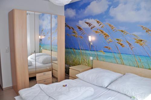 sypialnia z 2 łóżkami i malowidłem plażowym w obiekcie Ferienhaus Müritzbrise / EG-Appartement w mieście Marienfelde