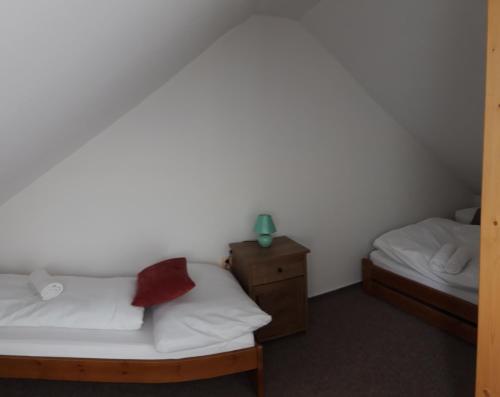 a room with two beds and a nightstand and a bed sidx sidx sidx sidx at Rodinný pension U Soudku in Rudník