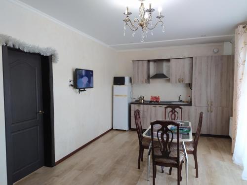 a kitchen and dining room with a table and chairs at Tulskiy Pryanik Home in Tul'skiy