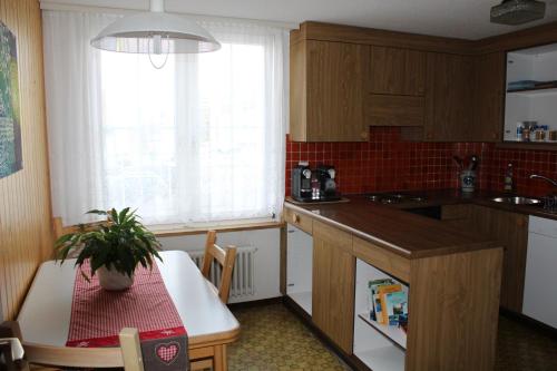a kitchen with a counter and a table and a window at Galluszentrum in Wildhaus