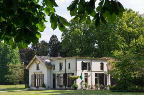 een uitzicht op een wit huis met bomen bij B&B en SPA Landgoed Matanze in Terwolde