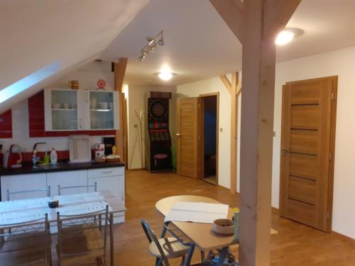a kitchen and living room with a table and chairs at Rodinný pension U Soudku in Rudník