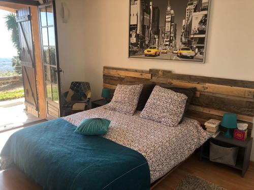 a bedroom with a bed with a wooden headboard at "Aux Balcons du Riou" avec vue mer 180 degrés in Vence