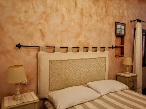 Villa La Quercia - Capriccioli في Abbiadori: غرفة نوم بسرير وليلتين وقفات مع لمبات