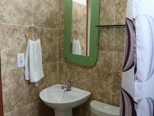 La salle de bains est pourvue d'un lavabo, de toilettes et d'un miroir. dans l'établissement Pousada Trevo Do Barbuda, à Búzios