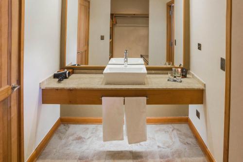 y baño con lavabo y espejo. en Hotel Cumbres Puerto Varas, en Puerto Varas