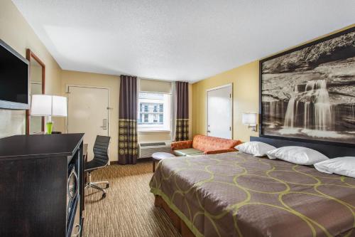 a hotel room with a bed and a flat screen tv at Super 8 by Wyndham Florence in Florence