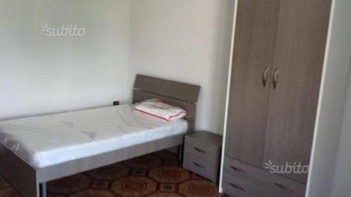 a small bedroom with a bed and a cabinet at ROOM in Capua