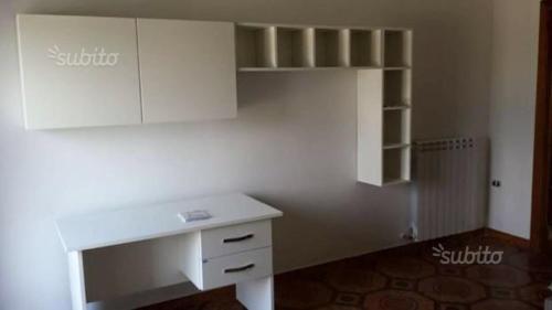 an empty room with a white desk and shelves at ROOM in Capua