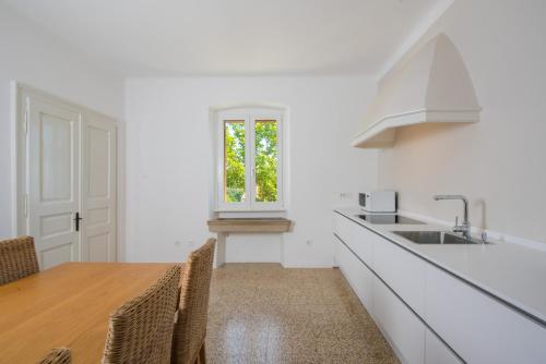 a kitchen with a table and a sink and a window at Villa Paula in Sveta Marina