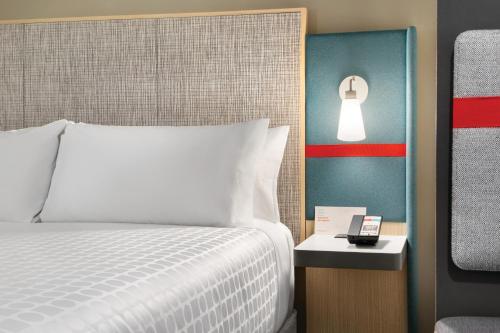 a bedroom with a bed and a lamp on a wall at avid hotel Augusta W - Grovetown by IHG in Grovetown