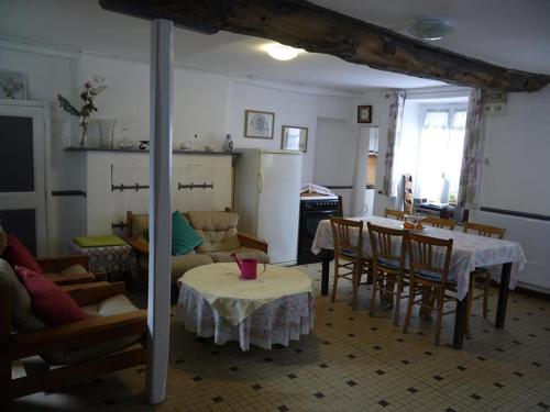 een keuken en een woonkamer met een tafel en stoelen bij les Miquelots in Pont-d'Ouilly