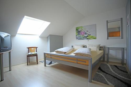 1 dormitorio con 1 cama y TV. en Ferienwohnung Ramstein, en Ramstein-Miesenbach