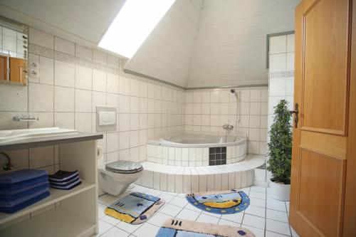 ein Badezimmer mit einer Badewanne, einem WC und einem Waschbecken in der Unterkunft Ferienwohnung Ramstein in Ramstein-Miesenbach