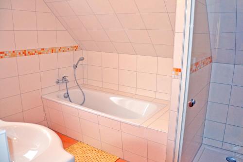 uma casa de banho com uma banheira, um WC e um lavatório. em Ferienhaus Müritzbrise / OG-Appartement em Marienfelde