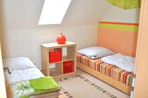 Dormitorio infantil con 2 camas y pared de arco iris en Ferienhaus Müritzbrise / OG-Appartement en Marienfelde
