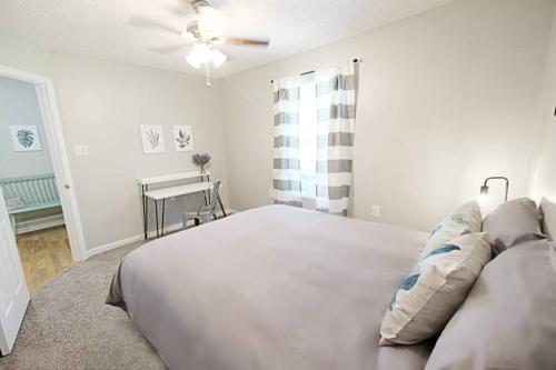 a white bedroom with a bed and a ceiling fan at Fresh Farmhaus by Design in Augusta in Augusta