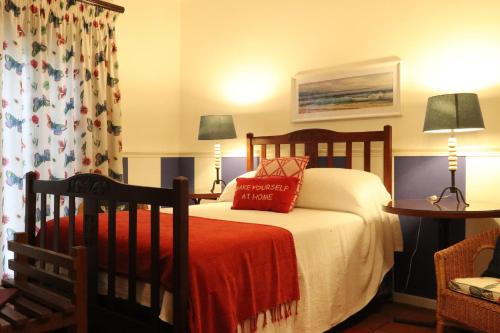 a bedroom with a bed and two tables with lamps at The Lighthouse Guesthouse in Colesberg