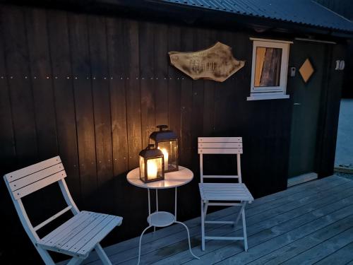 two chairs and a table with a candle on a deck at Hjallurin in Sandavágur