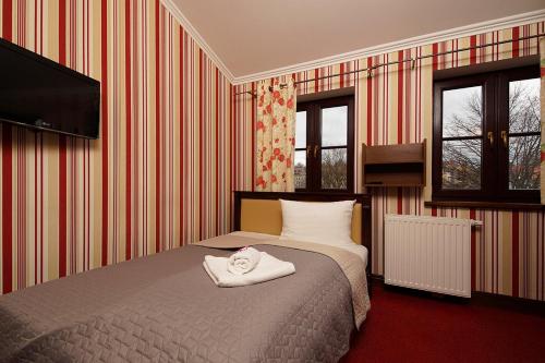 a bedroom with a bed with a towel on it at Hotelik & Restauracja Złota Kaczka in Zgorzelec