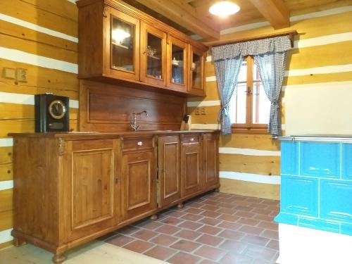 a kitchen with wooden cabinets and a window at Roubenka Telecí in Telecí