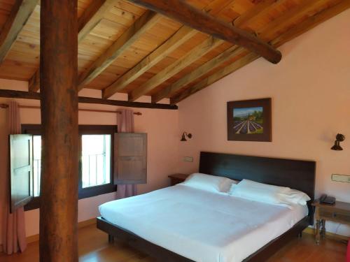 a bedroom with a large bed with a wooden ceiling at Antiguas Eras La Alberca in La Alberca