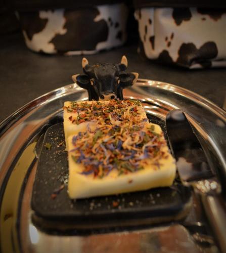 a cake with a cow on top of it on a plate at Gasthaus Alpina in Tschappina