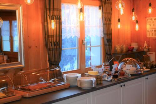a kitchen with a counter with dishes and a window at Gasthaus Alpina in Tschappina