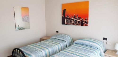 Habitación con 1 cama y 2 cuadros en la pared en Appartamenti Rho Fiera, en Pero