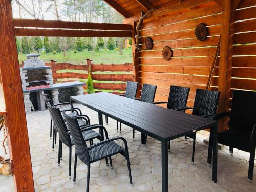 a table and chairs on a patio with a fireplace at Chaty Mazur w Wierzbie in Ruciane-Nida