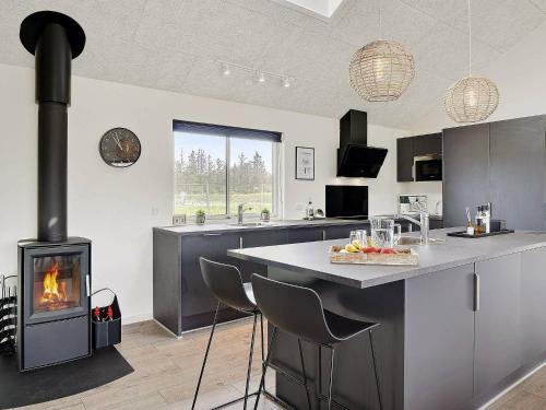 a kitchen with a stove in the middle of a room at 20 person holiday home in Nørre Nebel in Nørre Nebel