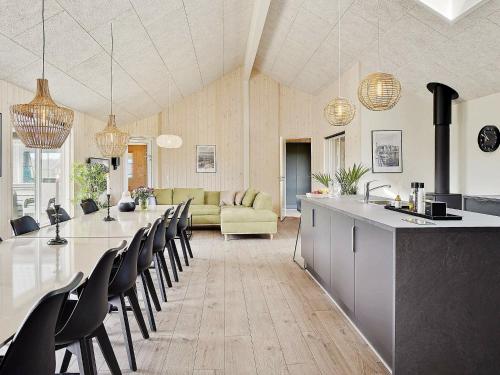 a kitchen and living room with a long table and chairs at 20 person holiday home in Nørre Nebel in Nørre Nebel