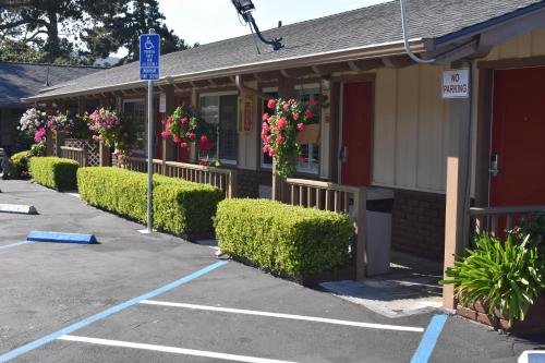 a building with bushes and flowers in a parking lot at Padre Oaks in Monterey
